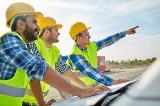 Group of construction workers pointing and wearing Hi-Viz yellow safety vests