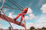 Worker at heights wearing Hi-Viz orange workwear, fall protection and hard hat